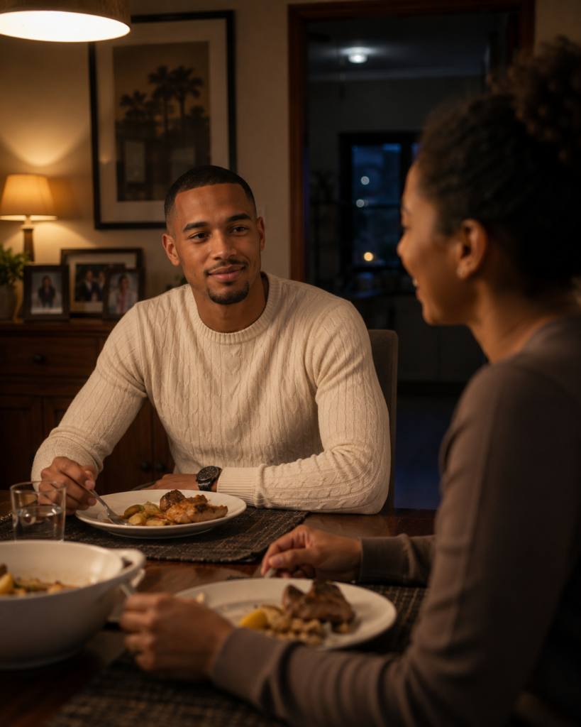 Young South African man quietly smiling across the dinner table while hiding the gradual loss of his authentic self